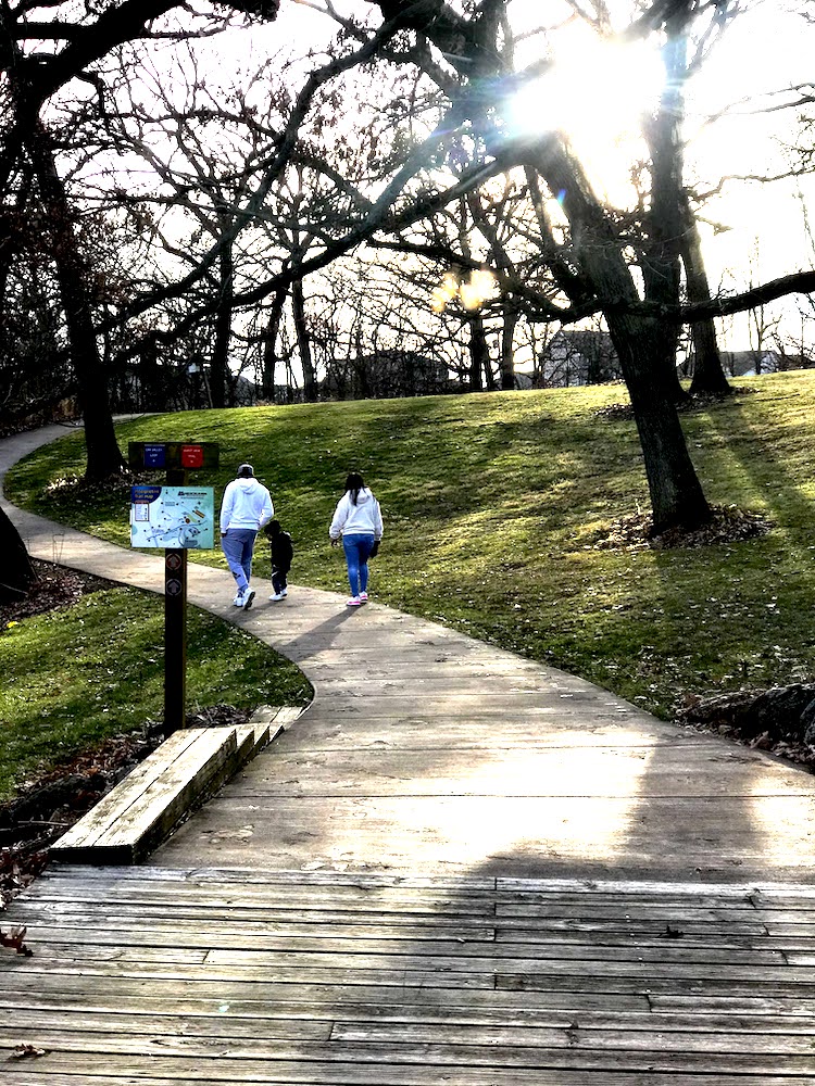 Family of three walking uphill of boardwalk path